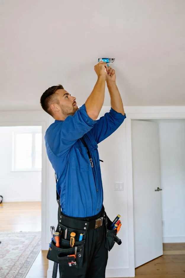 Electrician wiring a ceiling light fixture